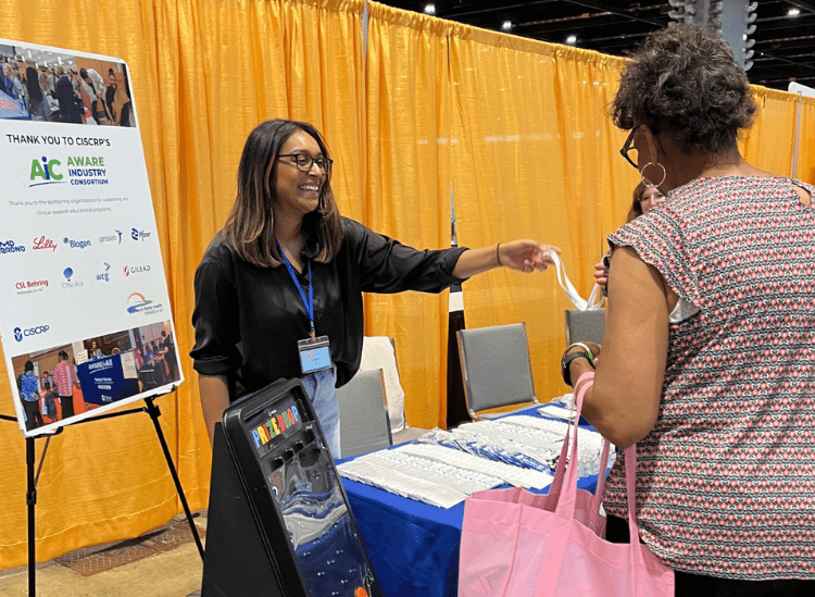 ciscrp team member at AWARE for All event sharing clinical research resource with attendee